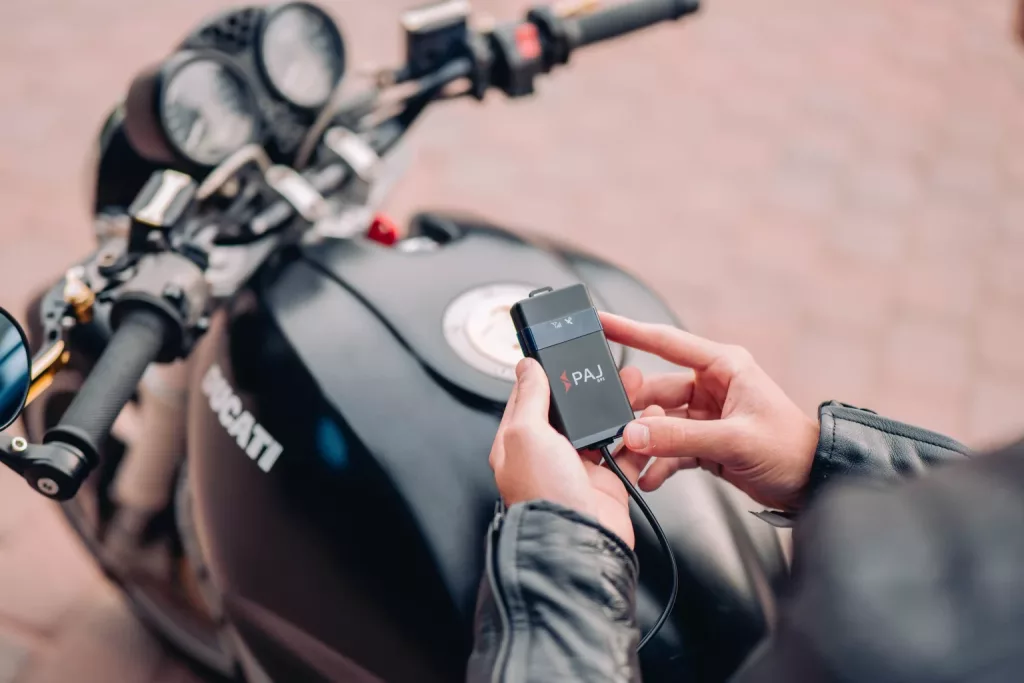 Homme tien un traceur GPS dans la main pour proteger sa moto
