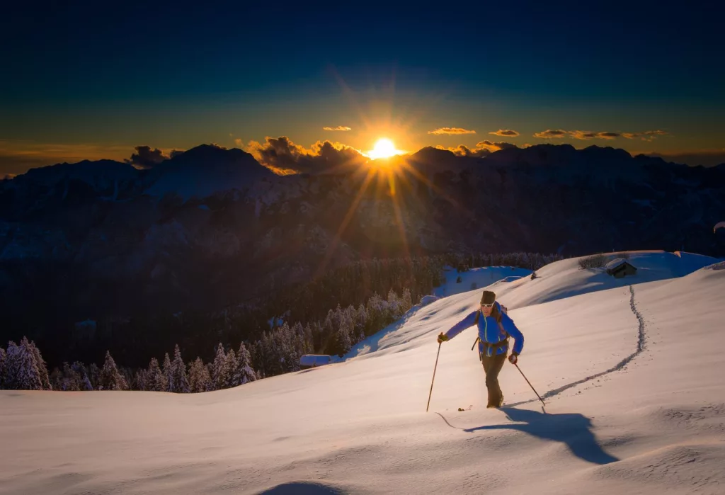 Ascension du sommet par skier en montagne dans le silence du coucher de soleil