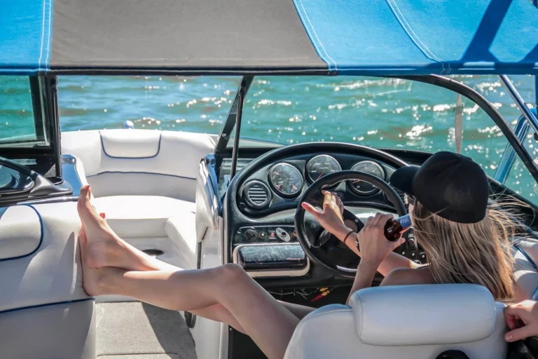 Une femme boit une boisson dans son bateau en pleine mer