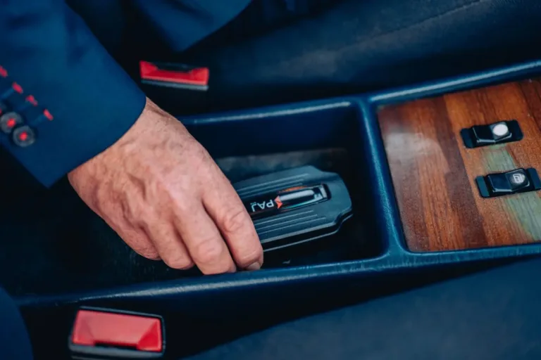 Business man pose un traceur GPS dans une Oldtimer