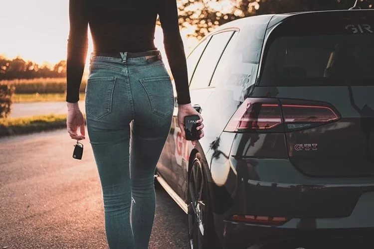 Une femme avec le power Finder de PAJ en main derriere une voiture