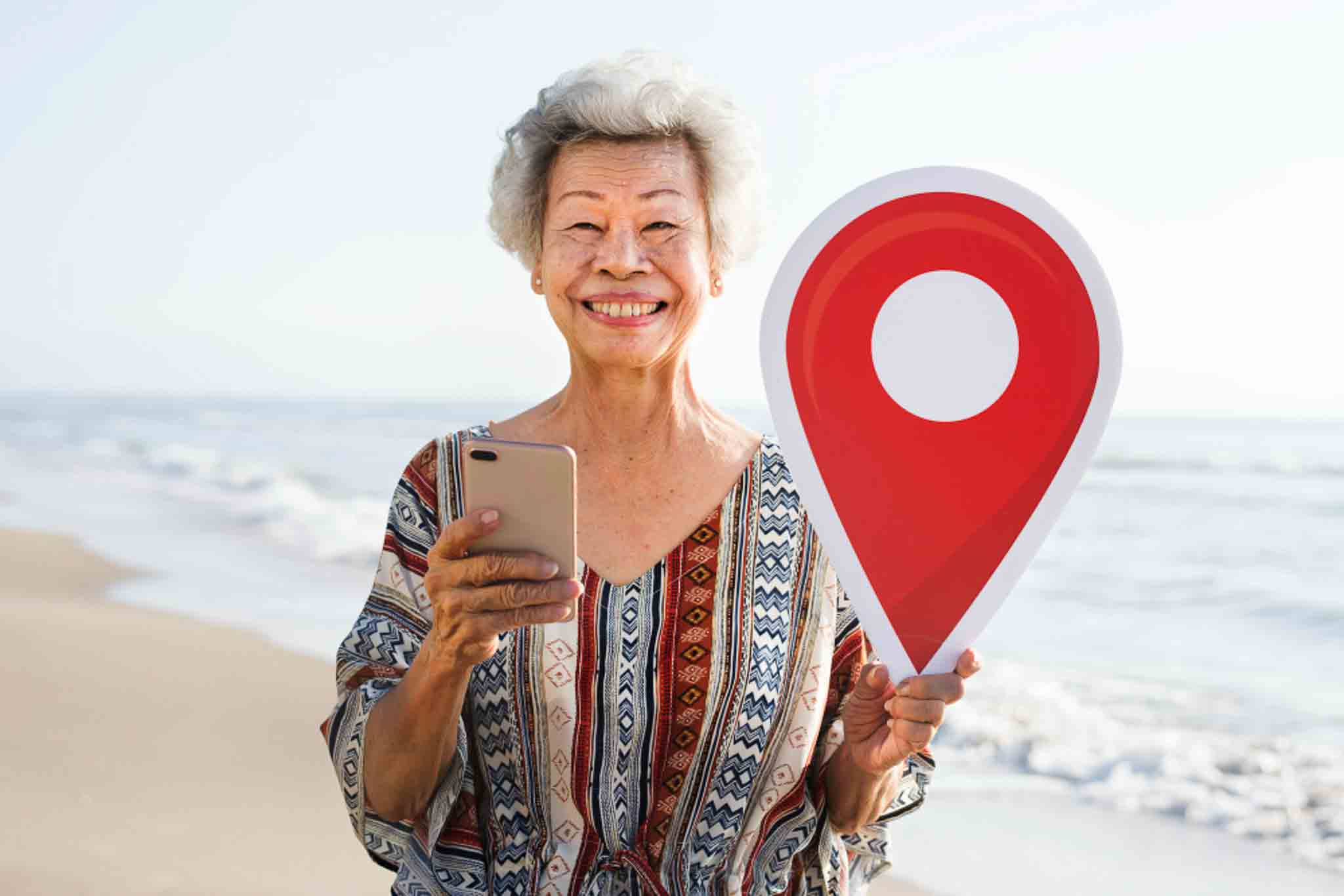 Une grandmere tien son telephone dune main et un signal de localisation GPS de lautre