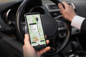 Un homme tien un téléphone dans la main pour géolocaliser sa voiture