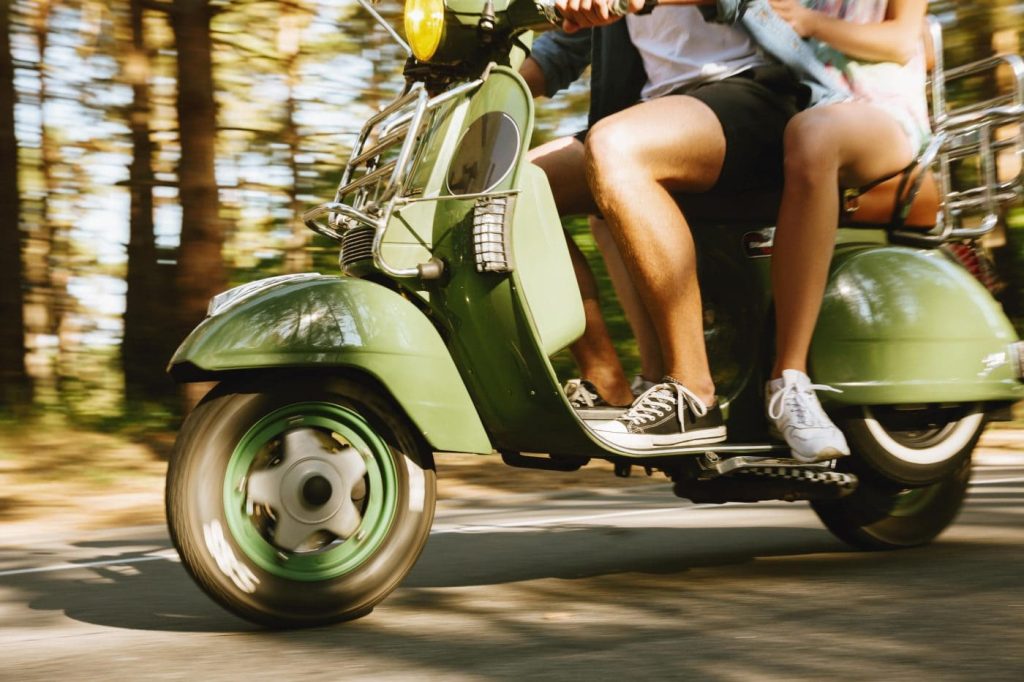 Un homme et une femme sur un scooter sur la route