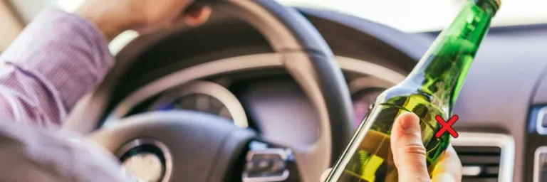 Une personne tient une bouteille dalcool au volant dune voiture